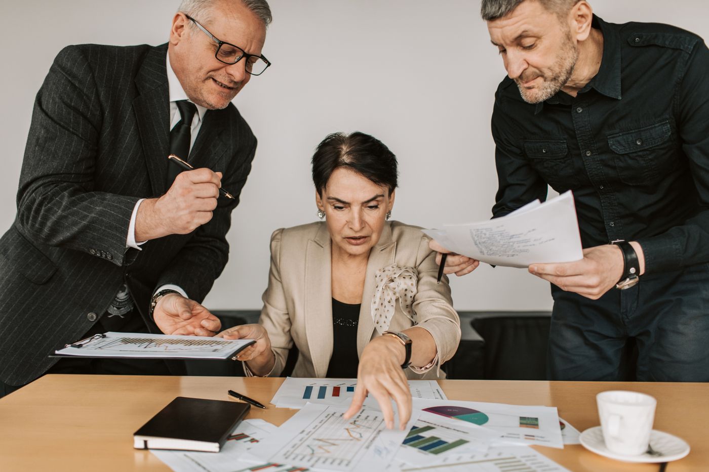 Three colleagues reviewing financial statements at a meeting table