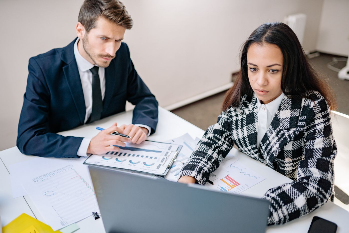 Two colleagues reviewing charts together at a laptop